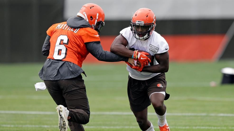 Quarterback Baker Mayfield hands the ball off to halfback Nick Chubb.